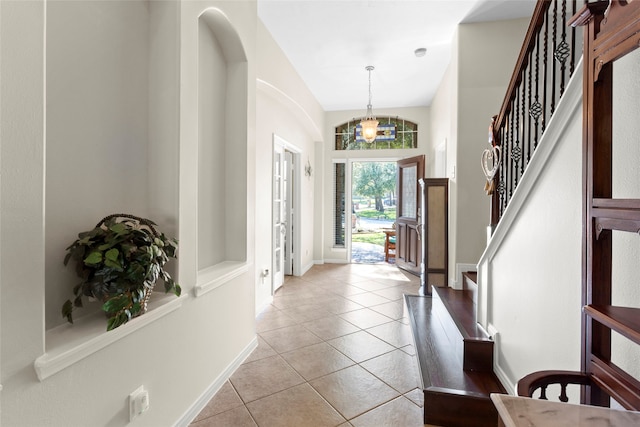 8707 Rolling Rapids Rd, Humble, TX 77346 - entrance foyer featuring light tile patterned floors, stairs, a chandelier, and arched walkways