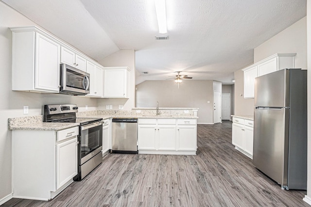 24134 Griffin House Ln, Katy, TX 77493 - kitchen with appliances with stainless steel finishes, a ceiling fan, a peninsula, light wood finished floors, and white cabinetry