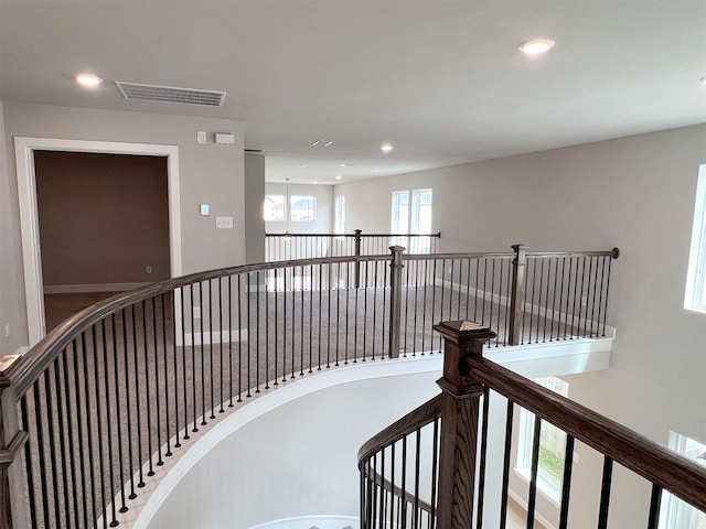 hall with recessed lighting, visible vents, and an upstairs landing