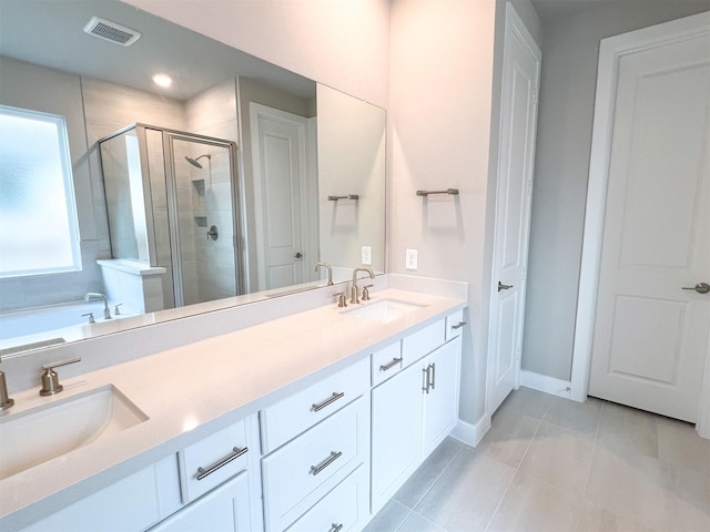 full bathroom featuring visible vents, a sink, a shower stall, and double vanity