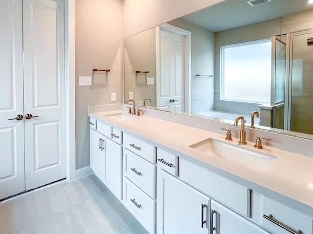 full bathroom with double vanity, a shower stall, visible vents, and a sink