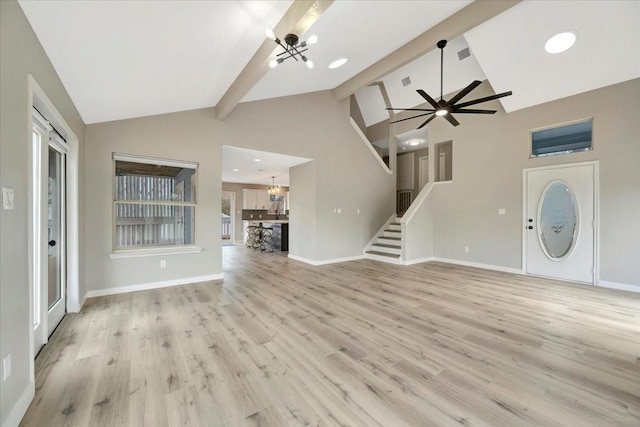 unfurnished living room featuring stairway, beam ceiling, light wood-style flooring, and baseboards