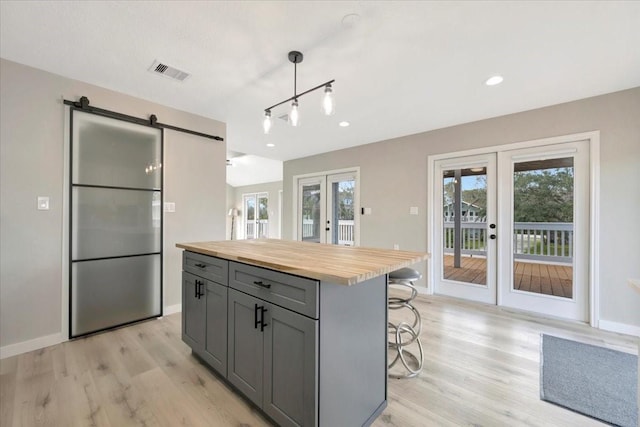 kitchen featuring a barn door, wood counters, visible vents, french doors, and gray cabinets