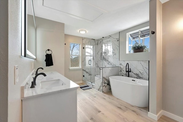 full bathroom featuring a sink, a soaking tub, a marble finish shower, and wood finished floors