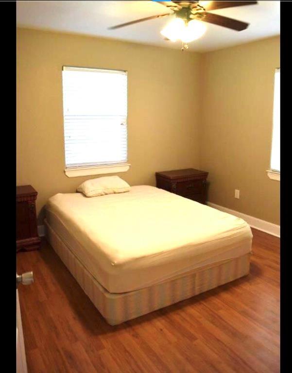 bedroom featuring a ceiling fan, baseboards, and wood finished floors