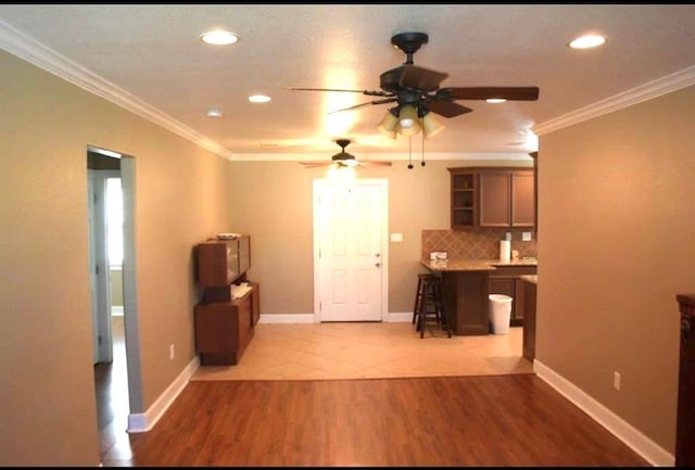 interior space featuring ornamental molding, baseboards, decorative backsplash, and open shelves