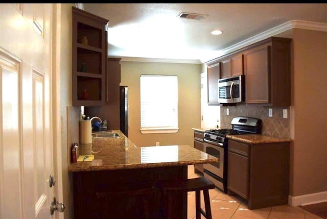 kitchen featuring crown molding, stainless steel appliances, open shelves, and decorative backsplash