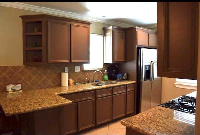 kitchen with a sink, ornamental molding, open shelves, tasteful backsplash, and stainless steel fridge