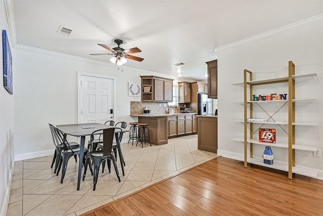 2009 Neumann Dr, Galveston, TX 77551 - dining space with ornamental molding, ceiling fan, light wood-style flooring, and baseboards