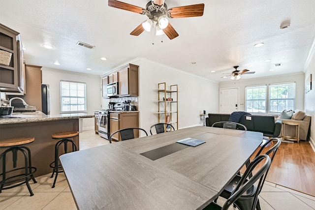 2009 Neumann Dr, Galveston, TX 77551 - dining room featuring a ceiling fan, light tile patterned floors, ornamental molding, recessed lighting, and baseboards