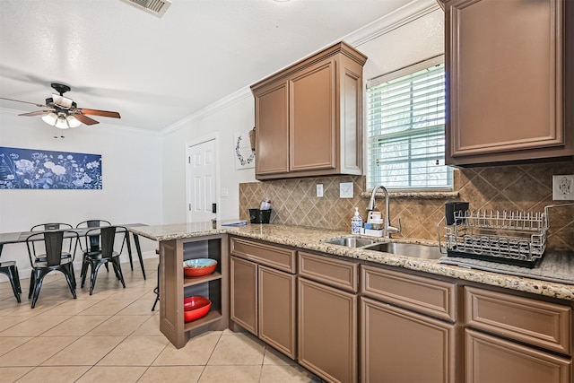 2009 Neumann Dr, Galveston, TX 77551 - kitchen featuring light tile patterned flooring, a sink, ceiling fan, ornamental molding, and decorative backsplash