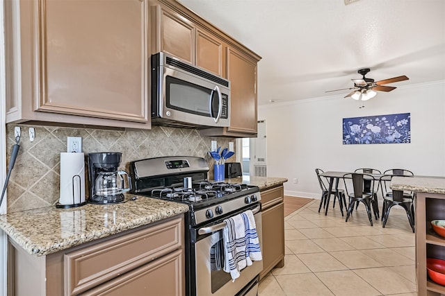 2009 Neumann Dr, Galveston, TX 77551 - kitchen with stainless steel appliances, ornamental molding, tasteful backsplash, light tile patterned flooring, and ceiling fan