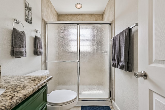2009 Neumann Dr, Galveston, TX 77551 - bathroom with toilet, a shower stall, vanity, and a textured wall