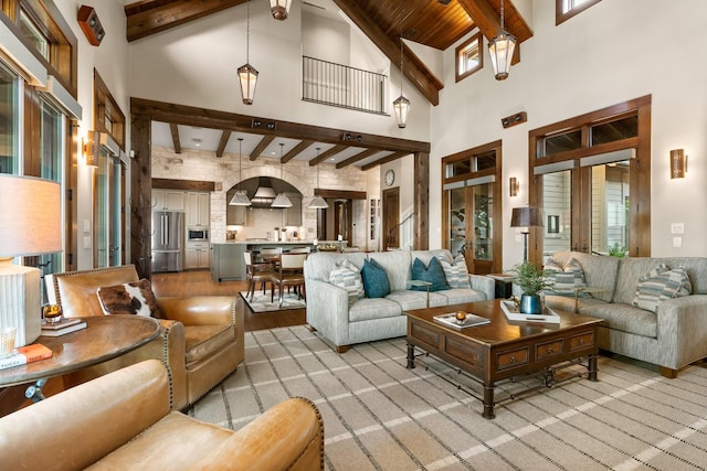 living room featuring a towering ceiling, wooden ceiling, and beamed ceiling