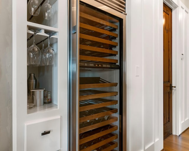 wine area with wine cooler and wood finished floors