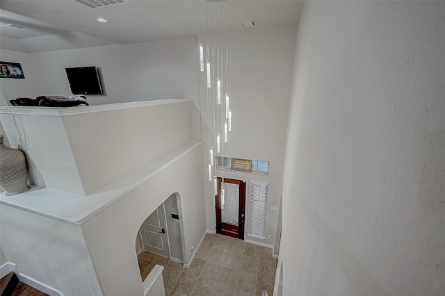 foyer featuring a high ceiling, visible vents, and baseboards