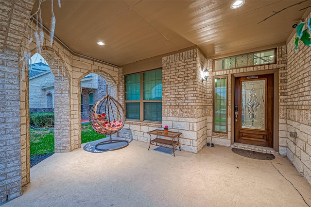 doorway to property with brick siding and a porch