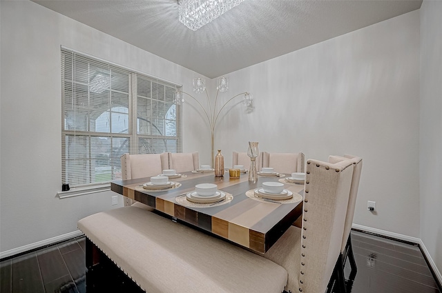 dining area featuring a textured ceiling, baseboards, and dark wood-type flooring