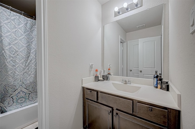 full bathroom with shower / tub combo, visible vents, and vanity