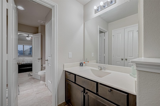 ensuite bathroom featuring ensuite bathroom, vanity, and toilet