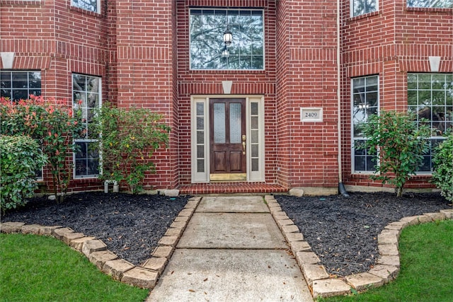 entrance to property featuring brick siding