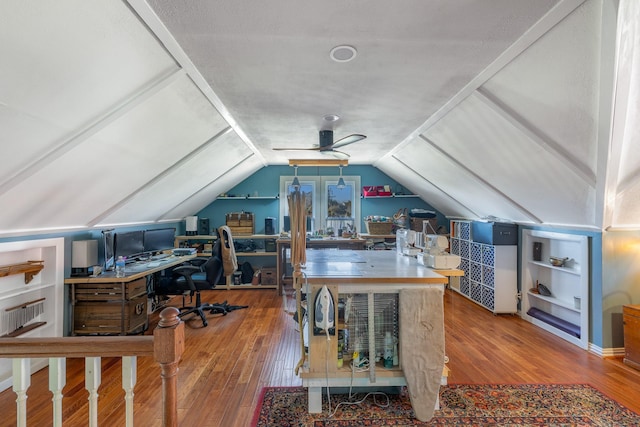 office space with vaulted ceiling, hardwood / wood-style floors, and a ceiling fan