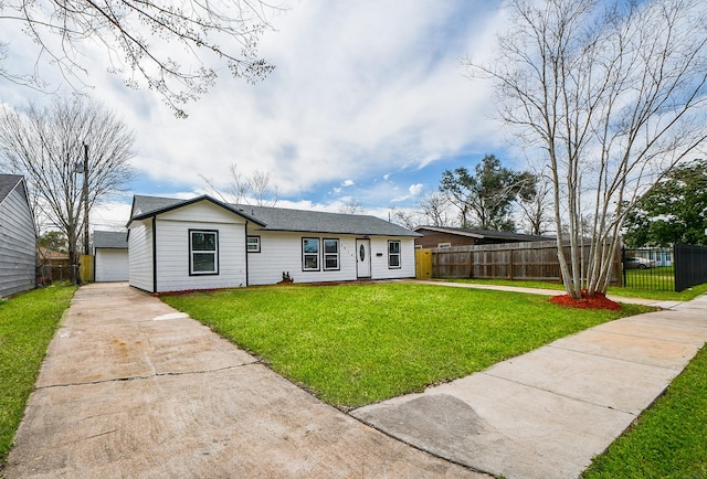 ranch-style house featuring a front lawn, an outdoor structure, fence, and a detached garage