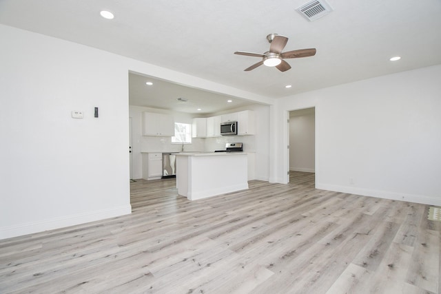 unfurnished living room featuring ceiling fan, light wood-style flooring, visible vents, and baseboards