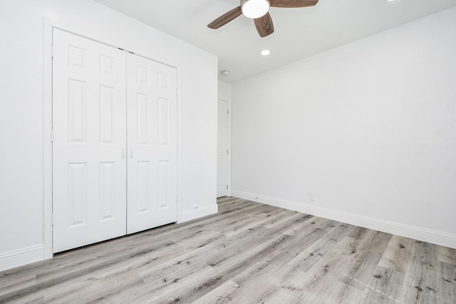 unfurnished bedroom with light wood-type flooring, baseboards, and a closet