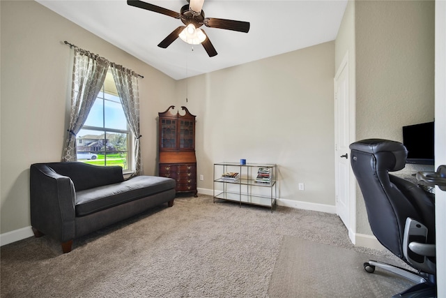 carpeted office space featuring ceiling fan and baseboards