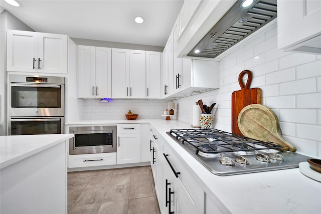 kitchen featuring range hood, stainless steel appliances, recessed lighting, decorative backsplash, and white cabinets