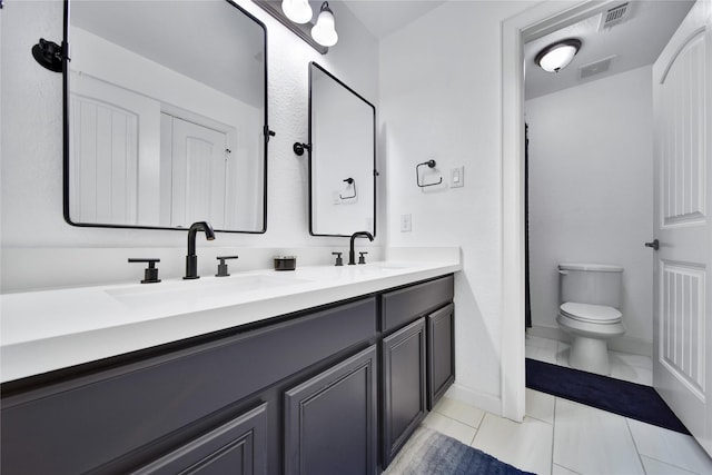 full bath with toilet, double vanity, a sink, and visible vents