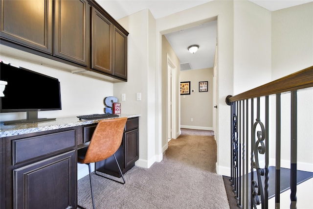 office featuring light carpet, visible vents, baseboards, and built in study area