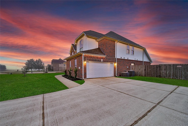 view of home's exterior featuring a garage, brick siding, fence, concrete driveway, and a lawn