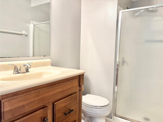 full bath featuring toilet, a shower stall, and vanity