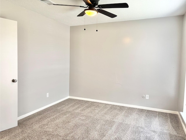 empty room featuring a textured ceiling, carpet floors, a ceiling fan, and baseboards