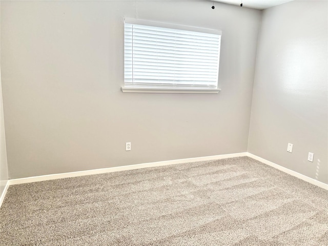 unfurnished room with baseboards and carpet flooring