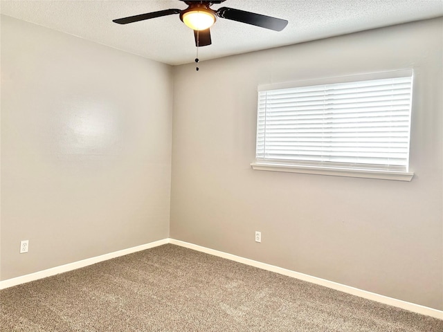 unfurnished room with a ceiling fan, carpet, a textured ceiling, and baseboards