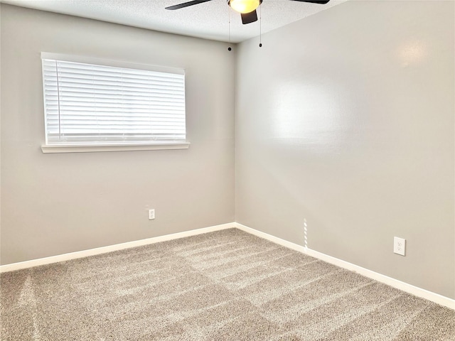 empty room featuring a textured ceiling, carpet flooring, a ceiling fan, and baseboards