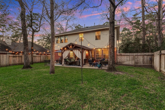 rear view of property featuring a gazebo, a patio area, a fenced backyard, and a yard