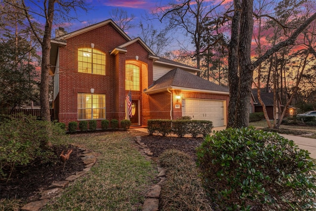 traditional home featuring an attached garage, a chimney, concrete driveway, and brick siding