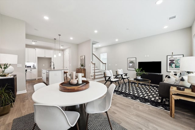 dining room featuring recessed lighting, visible vents, baseboards, stairs, and light wood-style floors