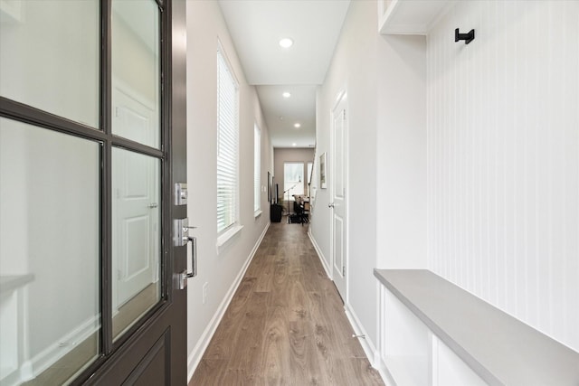 corridor featuring light wood-style floors, baseboards, and recessed lighting