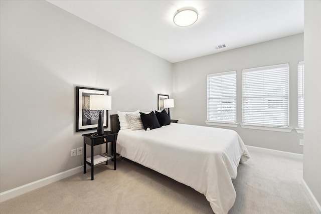 bedroom with baseboards, visible vents, and light colored carpet