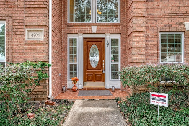 doorway to property with brick siding