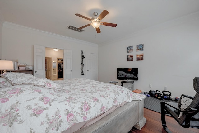 bedroom featuring ceiling fan, visible vents, dark wood finished floors, and crown molding