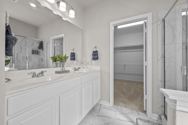 full bathroom featuring a sink, marble finish floor, and a marble finish shower