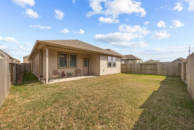 back of property with a yard, brick siding, a patio, and a fenced backyard