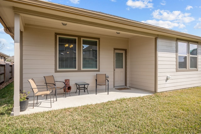 rear view of house featuring a lawn, a patio, and fence