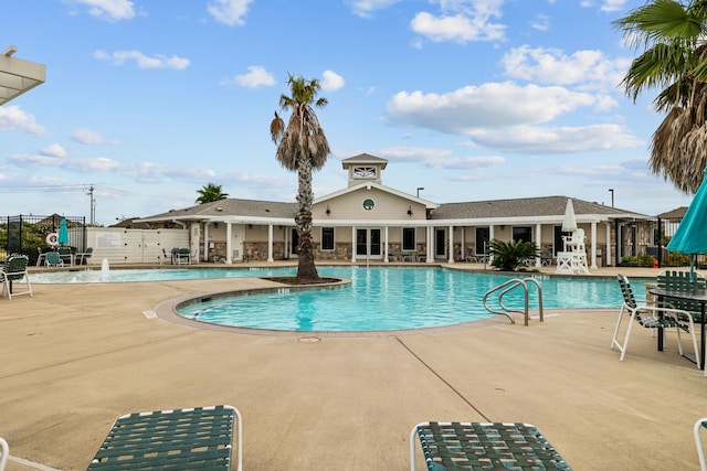 pool with a patio area and fence